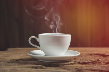 white coffee cup with smoke on wooden table