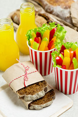 Table setting for a summer picnic - vegetables, juice and bread.