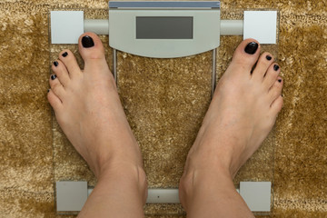 Close up female feet on digital weighti scale