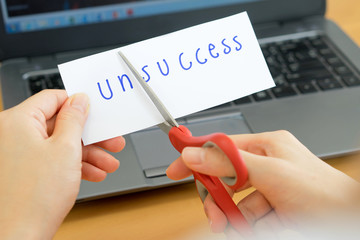 holds card with text unsccess on computer