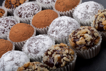 Round homemade chocolates in different kind of decor on paper su