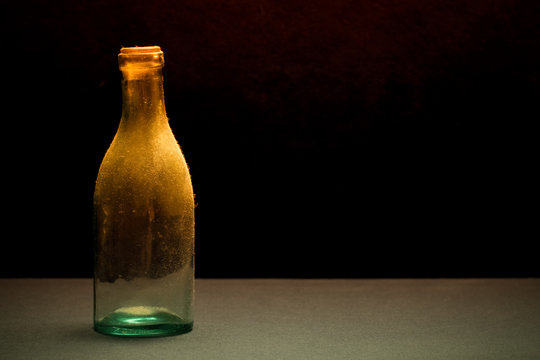 Ancient dust bottle on dark background. Selective focus. Shallow