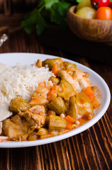 Ragout with chicken and okra or bamia or lady finger in white bowl on wooden background. Selective focus