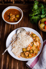 Ragout with chicken and okra or bamia or lady finger in white bowl on wooden background. Selective focus