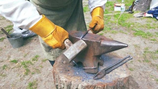 Blacksmith forges a product on the anvil