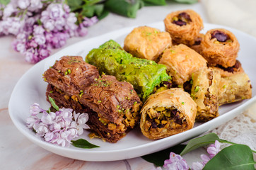 Mixed  baklava in white plate on marble background. Ramadan food, turkish arabian cuisine. Selective focus