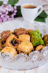 Mixed  baklava in white plate on marble background. Ramadan food, turkish arabian cuisine. Selective focus