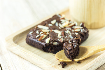 Brownie on wood plate with wooden mug on wood plank wall