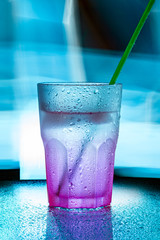 wet glass with green straw
