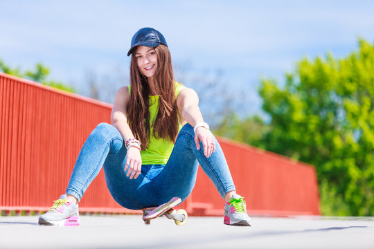 Teenage girl skater riding skateboard on street.