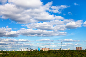 Fototapeta na wymiar white cloud in blue sky over city and green forest