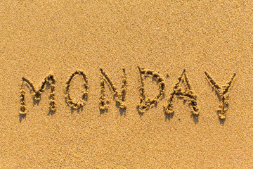 Monday - written by hand on a golden beach sand.