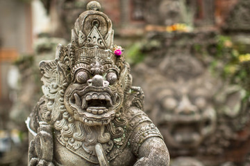 Traditional demon guard statue carved in stone in Bali island.