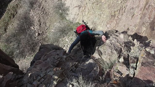 Mountaineer climbs over rocks