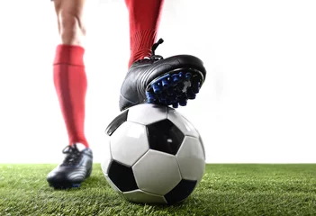 Poster legs feet of football player in red socks and black shoes posing with the ball playing on green grass pitch © Wordley Calvo Stock