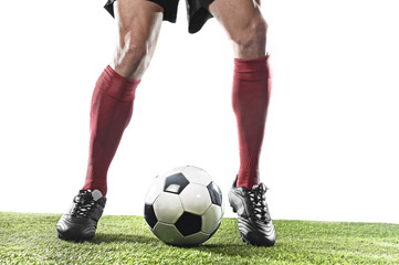 football player in red socks and black shoes running and dribbling with the ball playing on grass