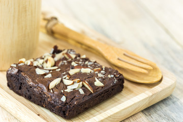 Brownie on wood plate with wooden mug on wood plank wall