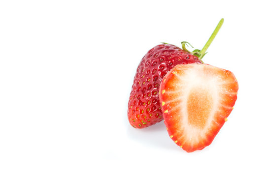 Strawberries and cut strawberry on white