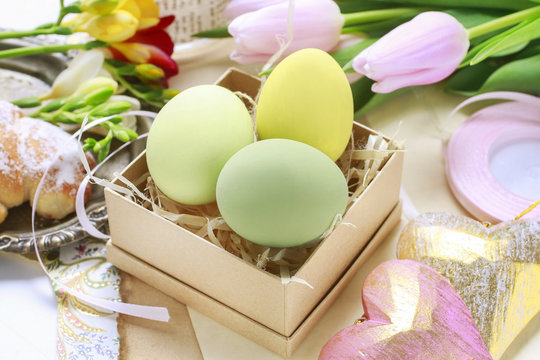Easter decorations: colorful eggs in paper box, spring flowers a