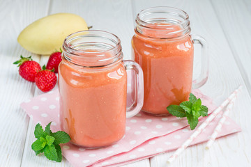 Healthy smoothie with strawberry, mango and banana in glass jars