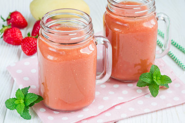 Healthy smoothie with strawberry, mango and banana in glass jars