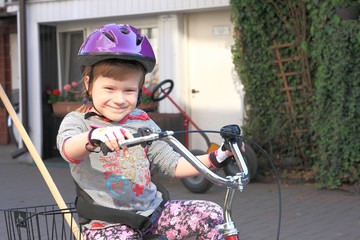 Obraz premium Little girl riding a three wheel rehabilitation bike