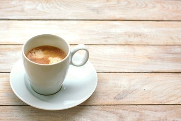Espresso in the cup on the wooden background