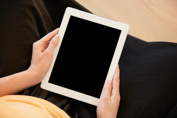 Cropped shot of redhead woman using wireless high-speed Internet connection on electronic tablet with blank copy space screen for your text or promotional content. Technology and communication concept