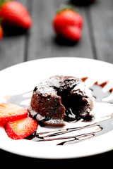 Chocolate fondant with strawberry on black wooden table