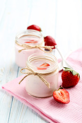 Strawberry yogurt in glass on a blue wooden table