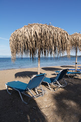 Straw umbrellas and sunbeds on a sandy beach, Corfu, Greece
