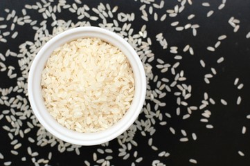 Risotto rice in the bowl on the black background