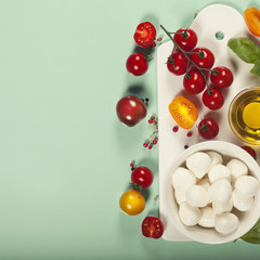 White ceramic serving board and salad ingredients over light blu