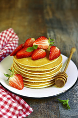 Pancakes with honey and strawberry.