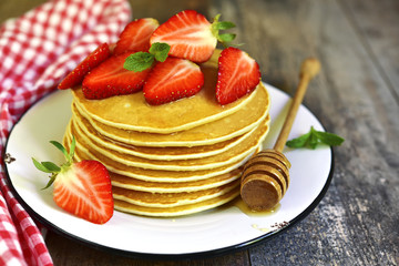 Pancakes with honey and strawberry.
