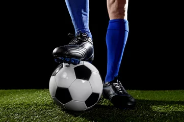 Fototapete Rund legs and feet of football player in blue socks and black shoes posing with the ball playing on green grass © Wordley Calvo Stock