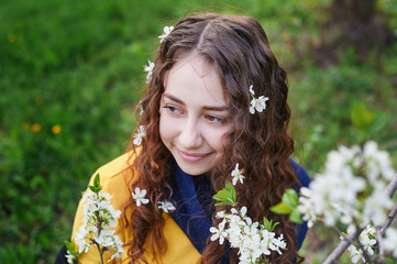 close up of beautiful young woman walking in a blossoming spring garden