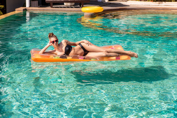 Sexy girl with orange mattress at pool party