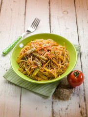 spaghetti with tomatoes green pepper and sesame seeds, selective focus