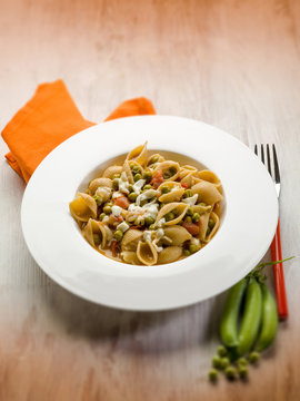 pasta with mozzarella fresh peas and tomatoes, selective focus