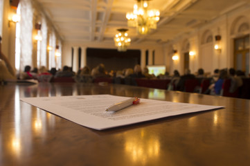 Pen on paper on Blured background of press conference