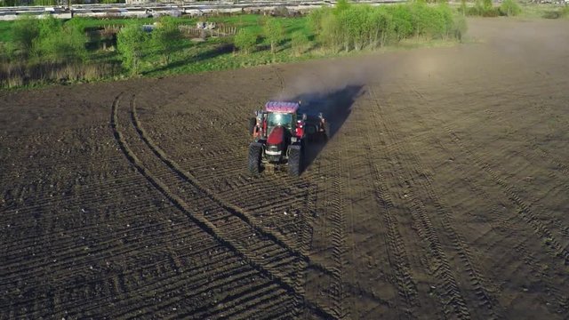 Farm tractor working in the field. Aerial footage.