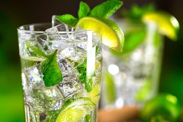 Foto auf Acrylglas Cocktail Mojito-Cocktail auf einem Tisch. Sommercocktail mit Rum, Limette, Minze, Eiswürfeln und braunem Zucker