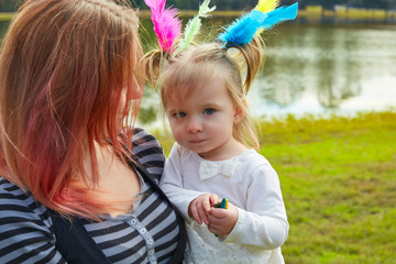 Mother and daughter playing with feathers in park