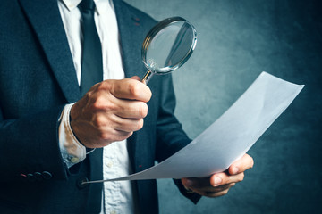 Tax inspector investigating financial documents through magnifying glass - obrazy, fototapety, plakaty
