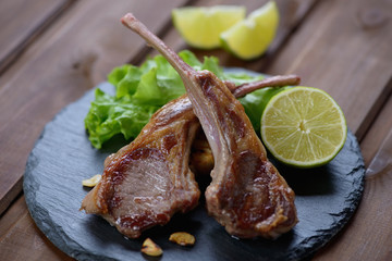 Stone slate with barbecued lamb steaks and fresh salad, close-up