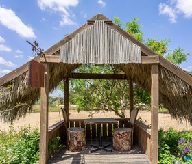Wooden pergola, roof covered with palm branches