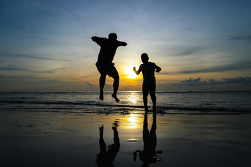 boys jumping on the beach Sunset