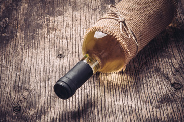 Bottle of white wine on rustic wooden background