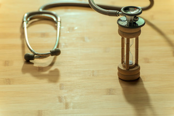 Top view of stethoscope and clock on the wood table , for background